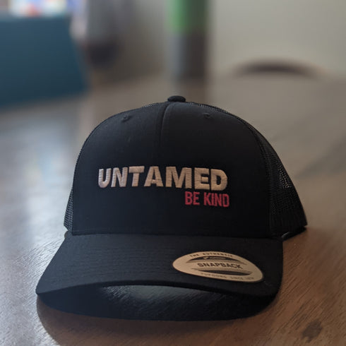 Black Flex fit baseball cap with pink embroidery slogan saying Untamed Be Kind.