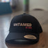 Black Flex fit baseball cap with pink embroidery slogan saying Untamed Be Kind.